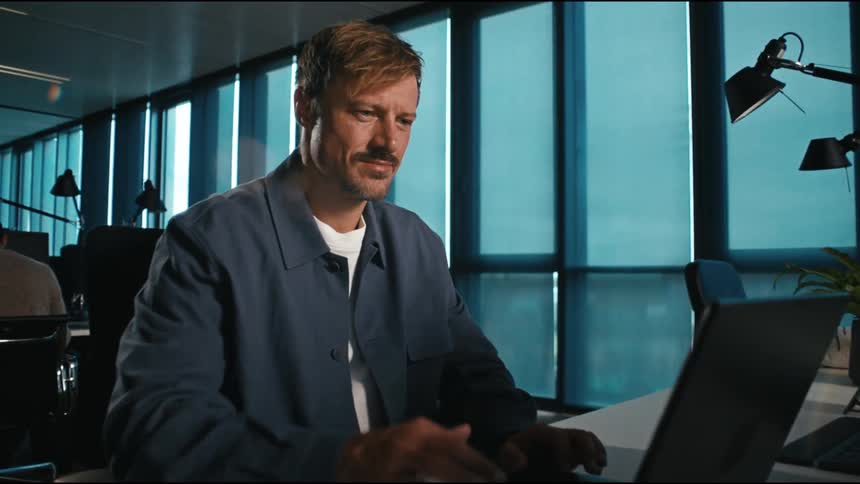 A man finishes typing, then presses enter happily