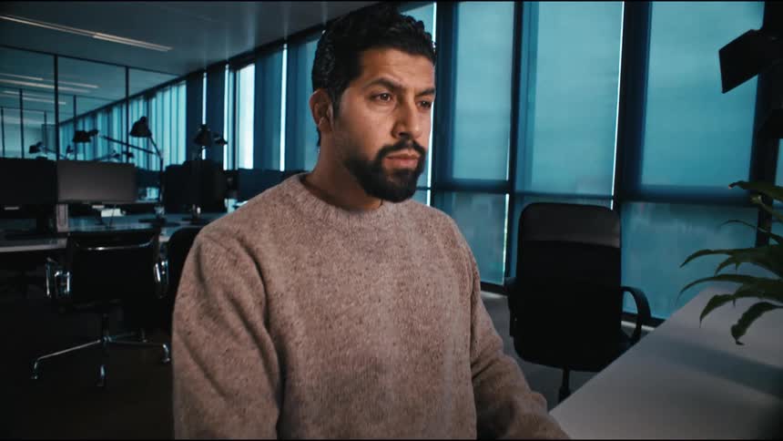 A man is focussed, working and typing at his desk