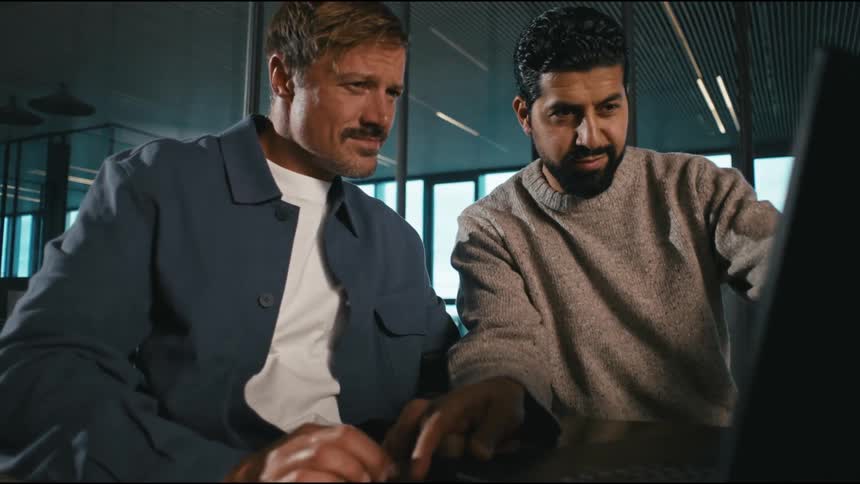 a man shows his coworker something on his laptop