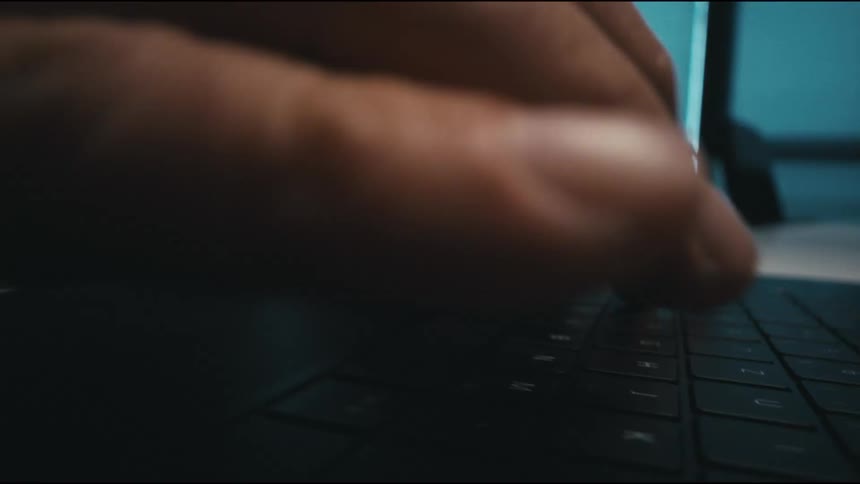 Man starts typing on a laptop keyboard