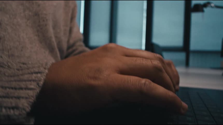 special camera move of a man finishing typing, then pressing enter