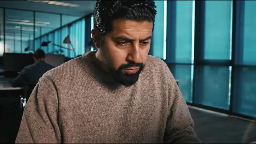 Man in office thinks then starts working