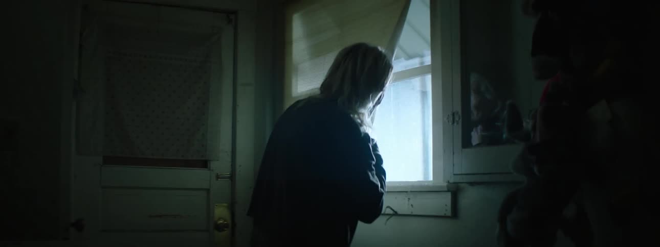 Woman looking out a window at flashing lights at night