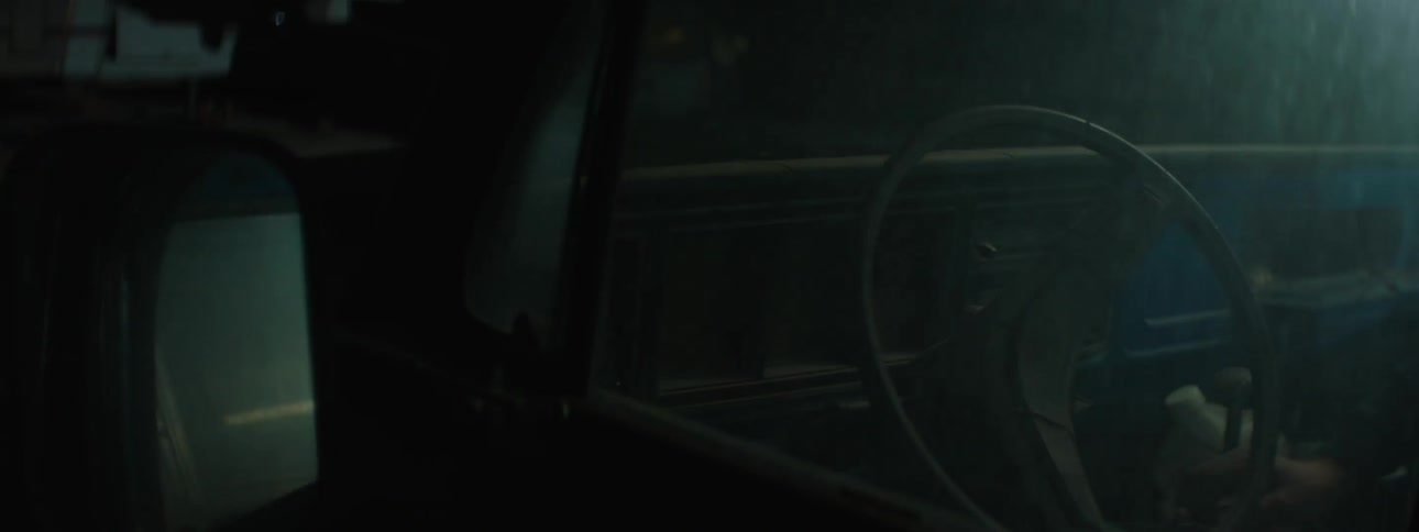 The steering wheel of a vehicle is shown at night