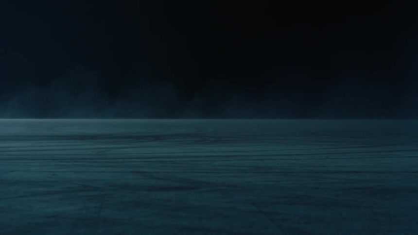 A car drives at night with its headlights on