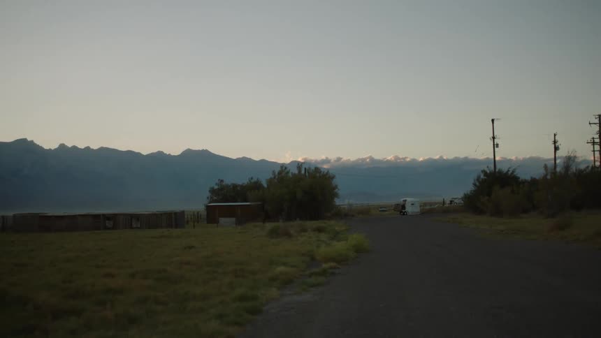 A rural area is shown with mountains in the distance