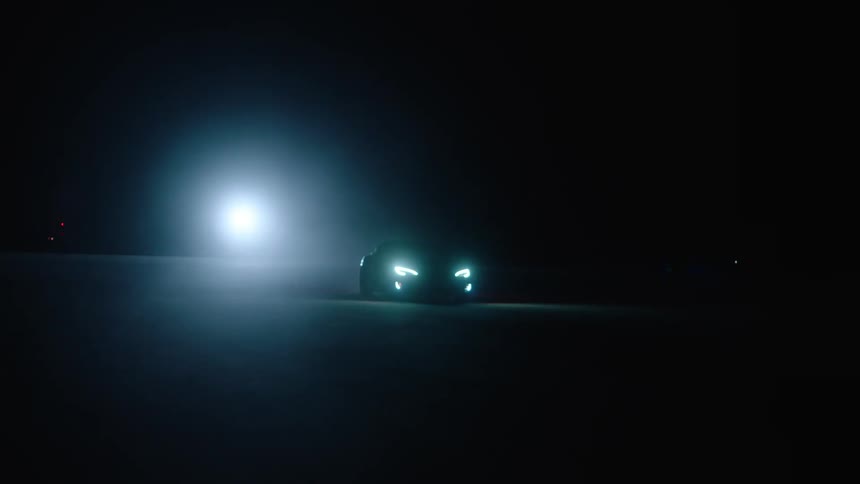 Car driving on pavement at night