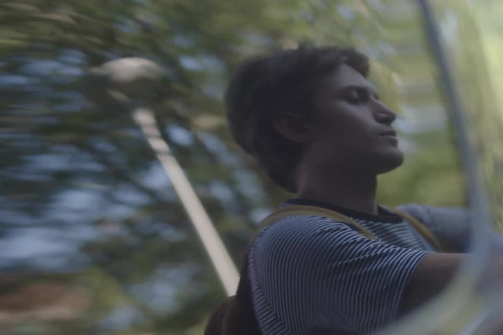 Man with a backpack looking upward under soft natural light