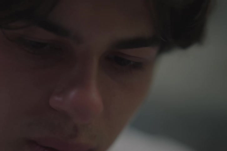 Man looking closely at something with a focused expression