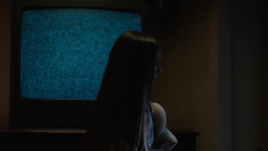 A girl taps the side of a television
