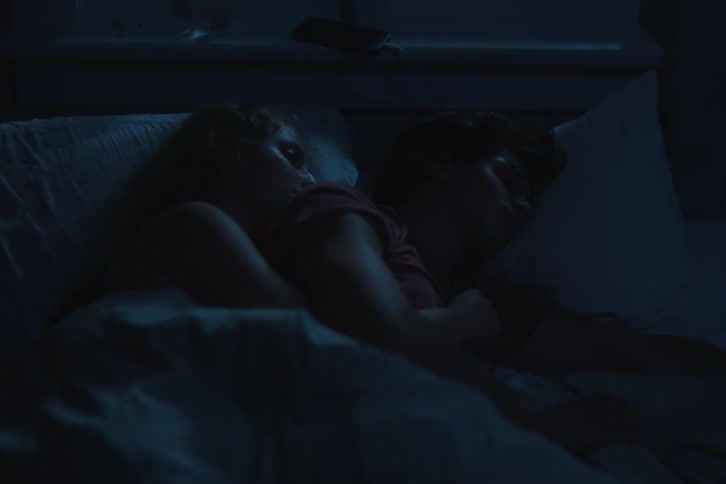 Couple sleeping together under the bluish night light
