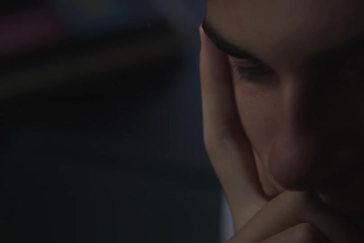 Man rests his face on his hand in a moment of reflection