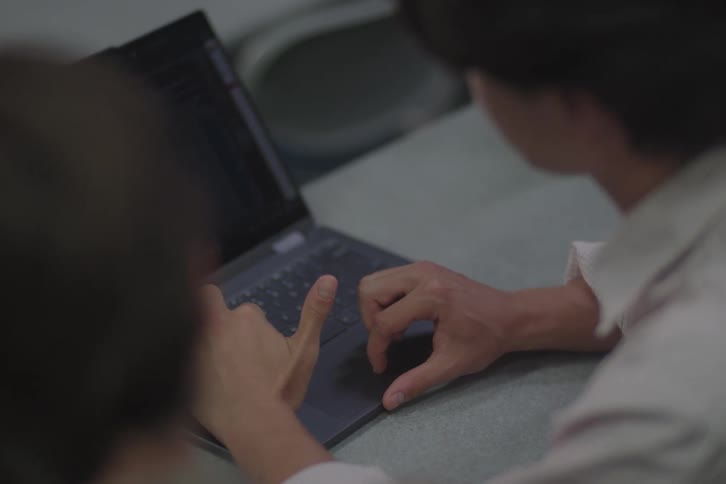 Two people collaborating on a laptop