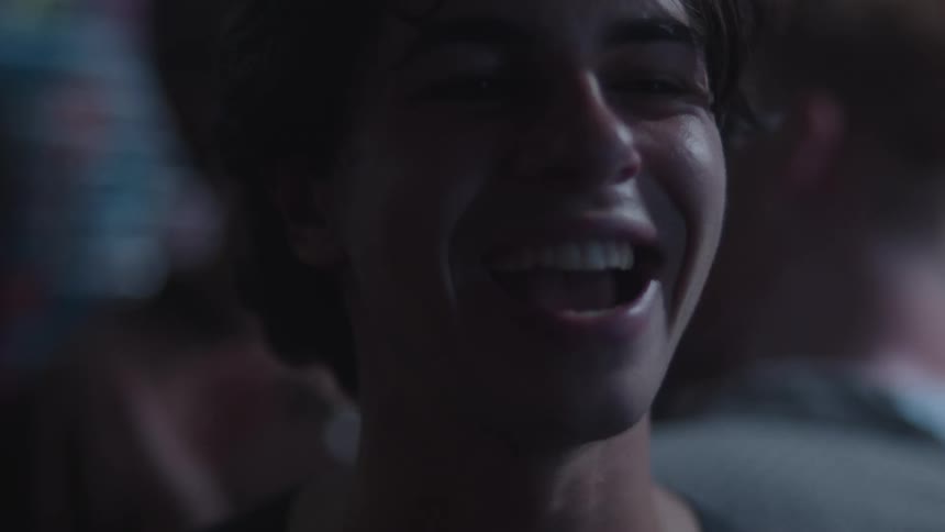Man laughing in the dim light of a festive setting