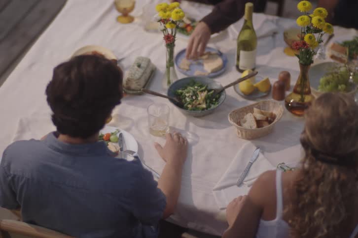 Couple holding hands at the table during an outdoor meal
