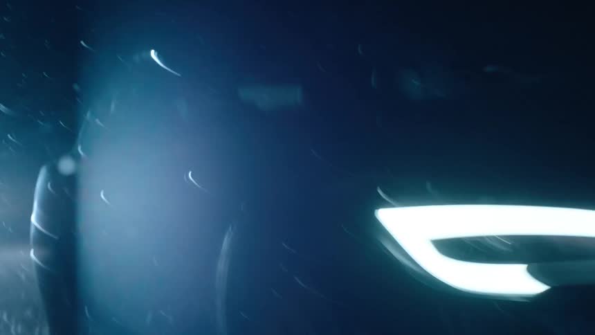 A car is moving in the dark with its lights on