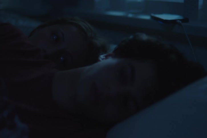 Two teenagers are laying in the bed at night