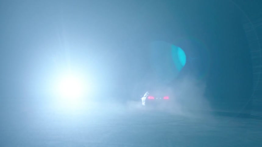A car races down the field towards a bright light