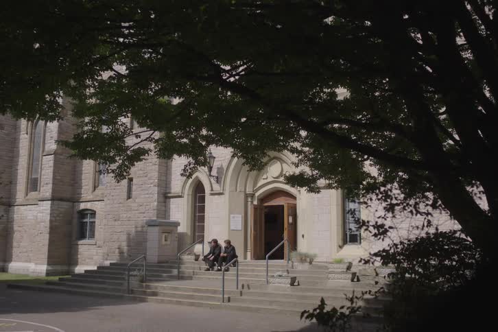 People sit on the steps in front of the church