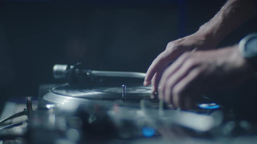 Hands operating a turntable during a musical performance