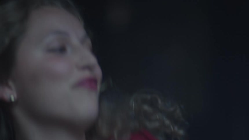 Woman dancing with a light expression under soft lighting