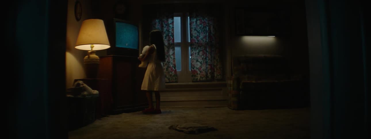 A child gets up to walk over to a television
