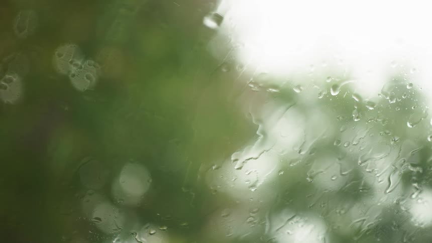 Closeup of a windshield wiper clearing raindrops on the car window