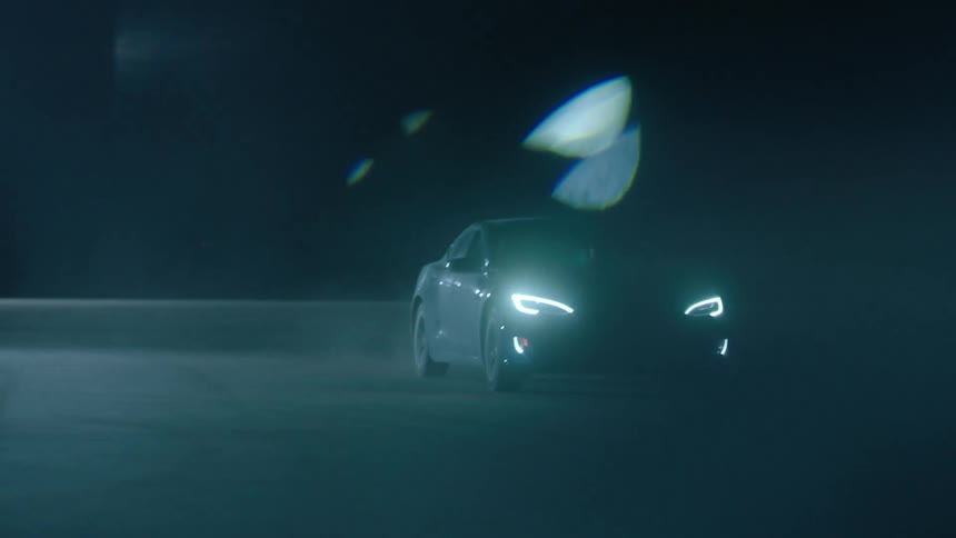 A car drives at night with its headlights on