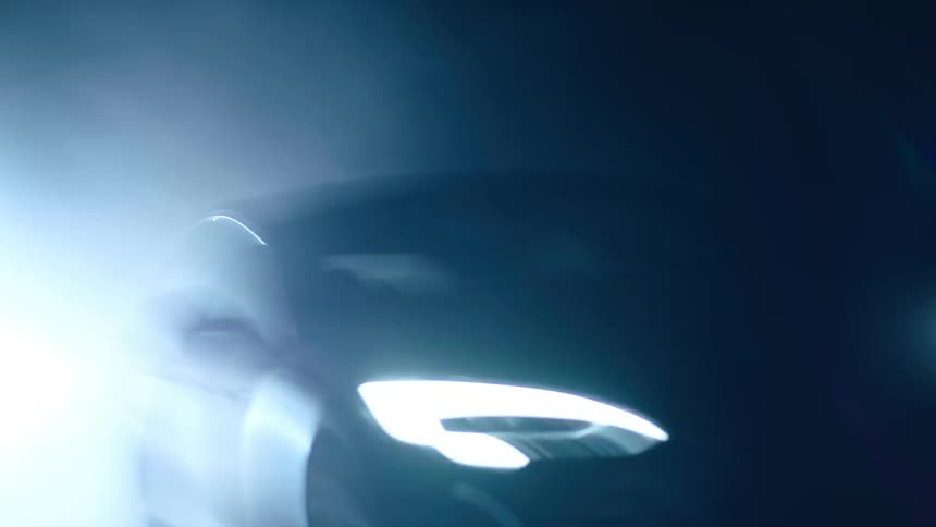 Bright car headlights bounce around on a road at night