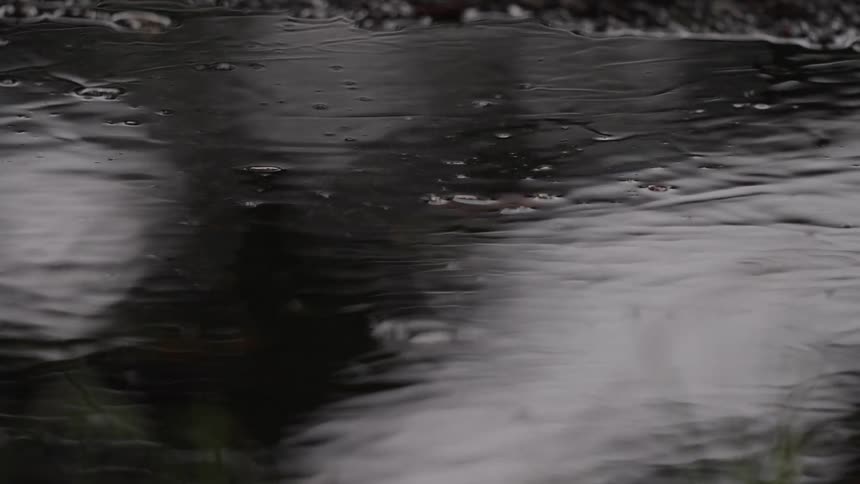 Closeup of rippling water with bubbles and blurred reflections