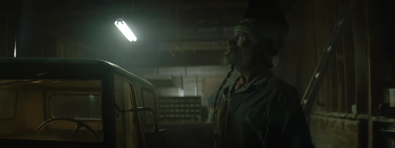 A man looks around a garage at blinking lights