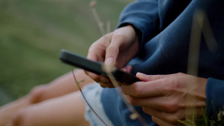 Person using a smartphone while sitting outdoors
