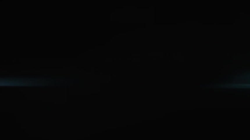 A car drives at night with its headlights on