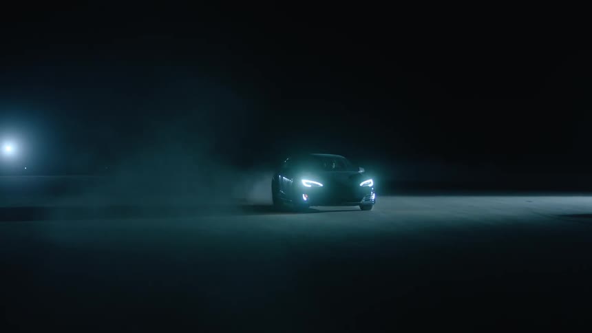 Car speeding at night being followed by two others in an open area