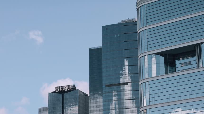 Mirrored facades of modern buildings reflecting the blue sky
