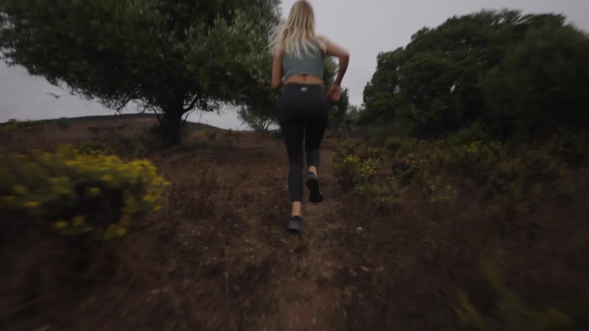 The woman is sprinting uphill