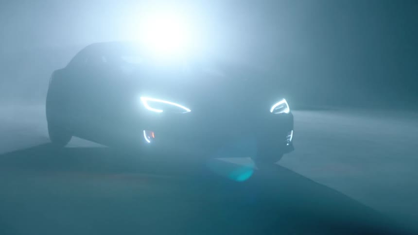 A car drives at night with its headlights on
