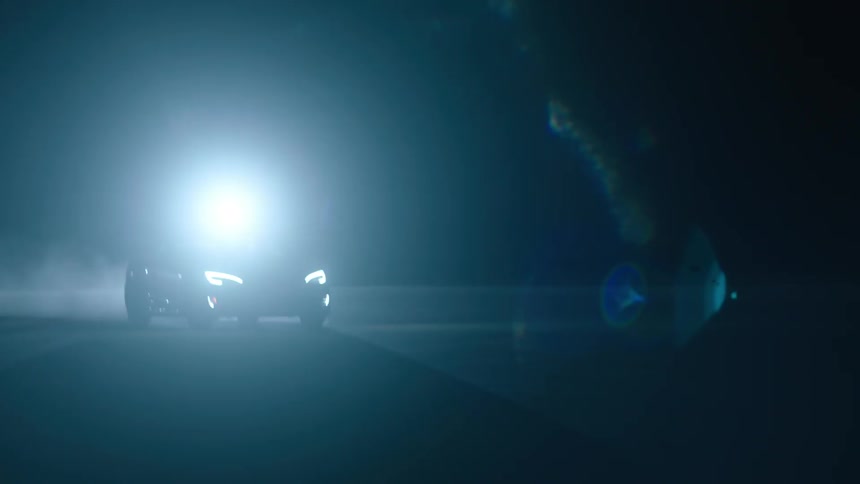 A car's headlights shine and reflect at night