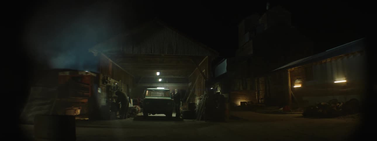 A person is working in the garage outside at night