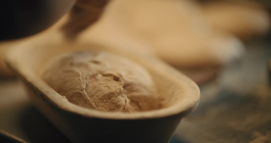 Bread dough being shaped in a loaf pan before baking