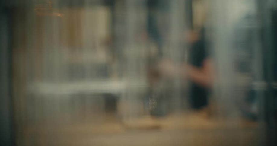 POV moving through a plastic partition into a small bakery