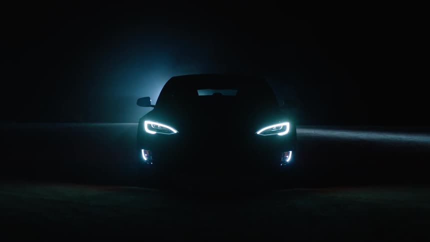 A car has it's lights on in the dark