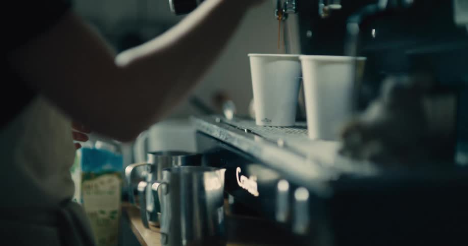 Person preparing espresso coffee in a professional machine