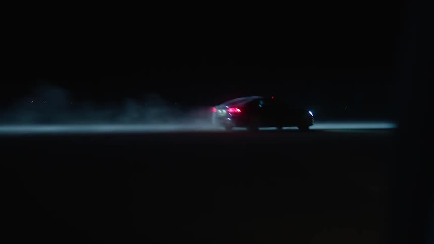 Car speeding over pavement at night