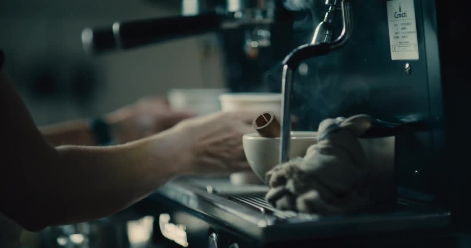 Close up of a woman filling disposable cups with hot beverages for serving in a cafe