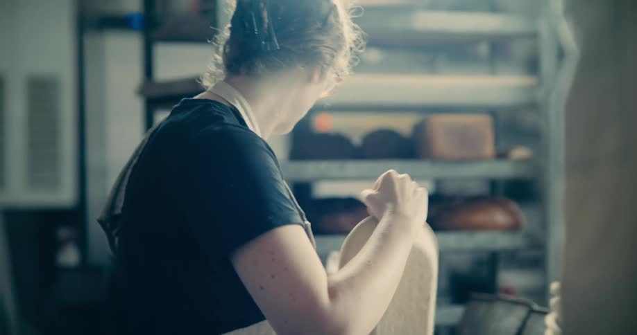 The baker carries bowls into the bakery