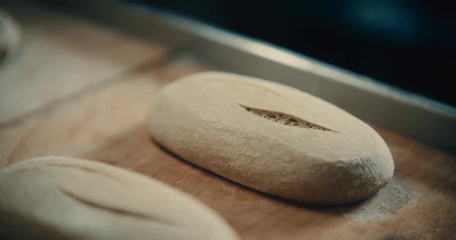 Close up of bread dough sprayed with a powdered ingredient