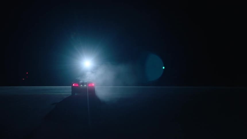 Car driving on pavement at night