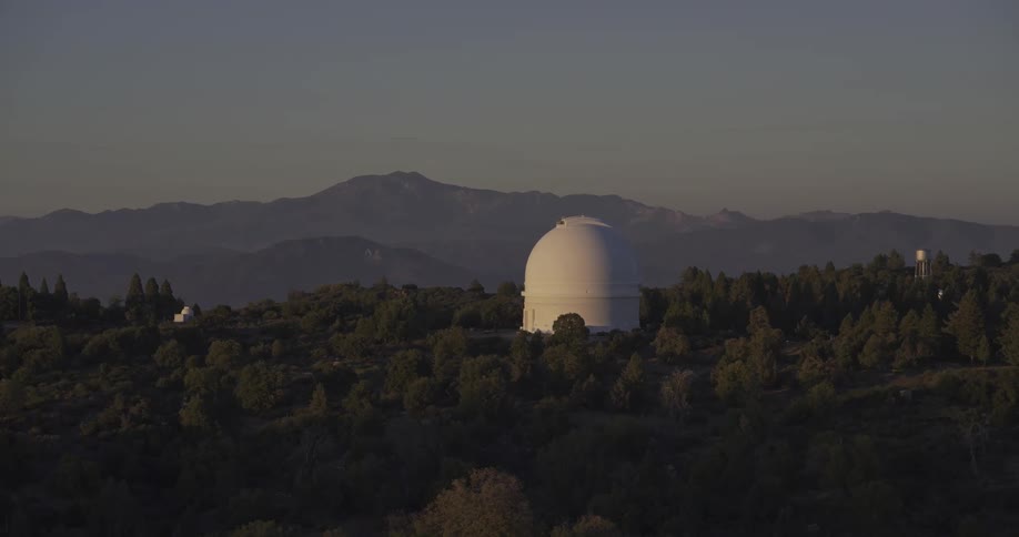 A large domed telescope is in the forest
