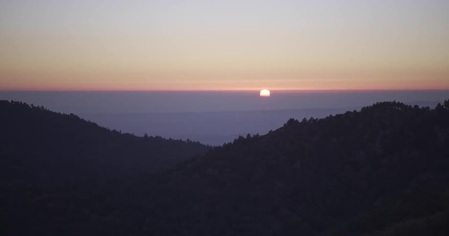 Aerial of mountains covered with forest vegetation at sunset